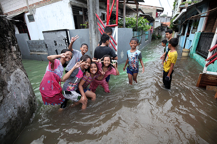 Anak-anak bermain banjir yang menggenangi Jalan Swadarma Raya, Petukangan, Jakarta, Sabtu (5/11/2022).
