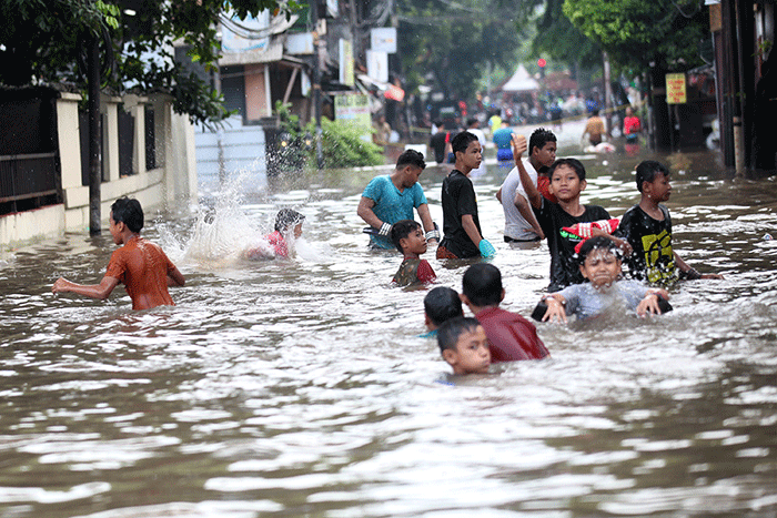 Anak-anak bermain banjir yang menggenangi Jalan Swadarma Raya, Petukangan, Jakarta, Sabtu (5/11/2022).