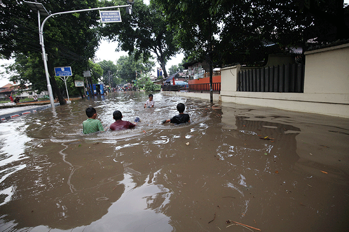 Anak-anak bermain banjir yang menggenangi Jalan Swadarma Raya, Petukangan, Jakarta, Sabtu (5/11/2022).