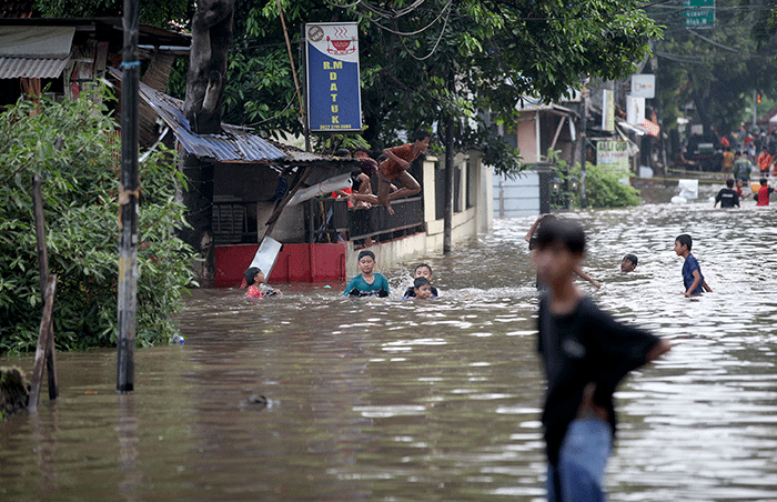 Anak-anak bermain banjir yang menggenangi Jalan Swadarma Raya, Petukangan, Jakarta, Sabtu (5/11/2022).
