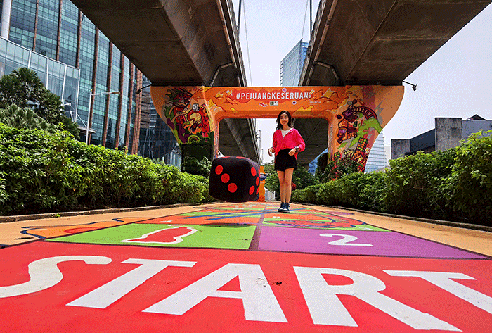 Pengunjung saat mencoba permainan tradisional ular tangga dengan menampilkan kolaborasi kreasi mural pertama antara Jakarta dan Fanta.