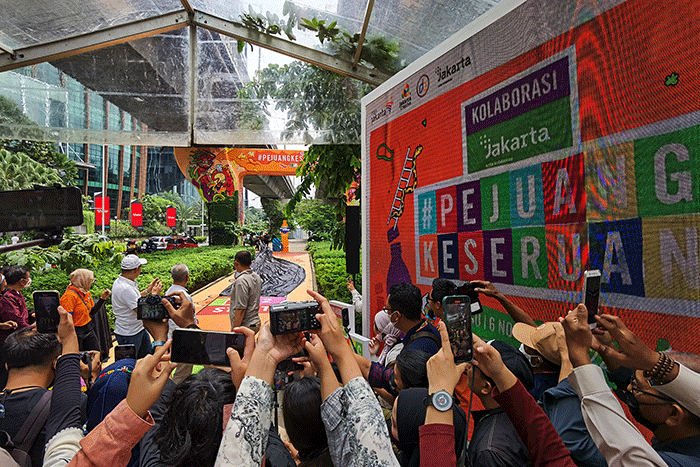 Pengunjung saat mencoba permainan tradisional ular tangga dengan menampilkan kolaborasi kreasi mural pertama antara Jakarta dan Fanta.