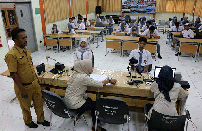 Petugas Kelurahan Pulau Panggang, Kecamatan dan Kabupaten Pulau seribu melakukan rekam e-KTP elektronik pada siswa-siswi SMA 69 Kepulauan Seribu Utara.