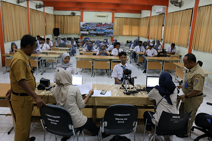 Petugas Kelurahan Pulau Panggang, Kecamatan dan Kabupaten Pulau seribu melakukan rekam e-KTP elektronik pada siswa-siswi SMA 69 Kepulauan Seribu Utara.