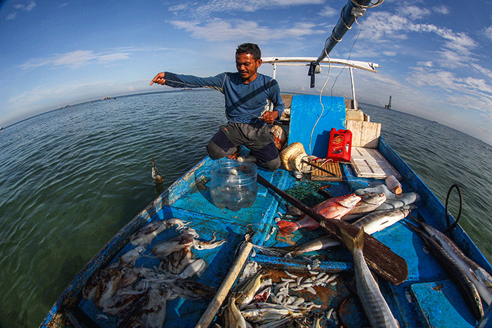 Nelayan mengganti oli mesin Mesran Super pada perahunya di Pulau Gusung, Makassar, Minggu (6/11/2022).