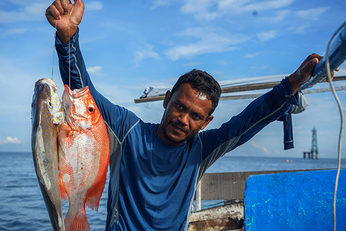 Nelayan mengganti oli mesin Mesran Super pada perahunya di Pulau Gusung, Makassar, Minggu (6/11/2022).