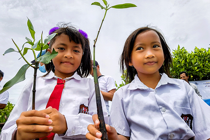 Para anggota Jurnalis Mancing Indonesia bersama anak anak sekolah dasar menanam bibit pohon mangrove di desa Ambulu, Kecamatan Losari, Kabupaten Cirebon.