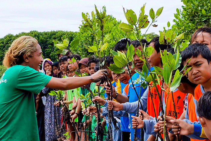 Para anggota Jurnalis Mancing Indonesia bersama anak anak sekolah dasar menanam bibit pohon mangrove di desa Ambulu, Kecamatan Losari, Kabupaten Cirebon.