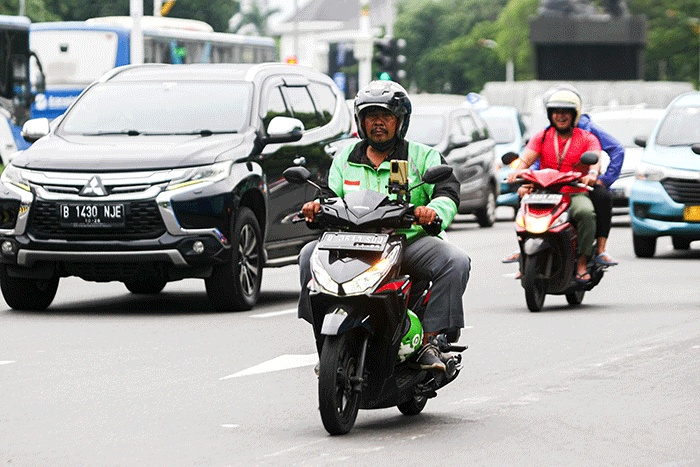 Driver Gojek saat melintas di kawasan Jakarta, Jumat (18/11/2022).