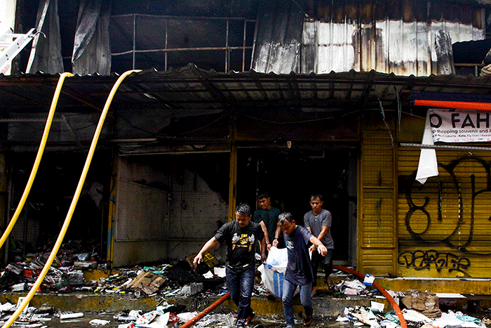 Sejumlah pedagang mencari kembali barang-barang yang masih tersisa akibat terbakar sebanyak 20 kios di Pasar Pagi Asemka, Jakarta, Jumat (18/11/2022).