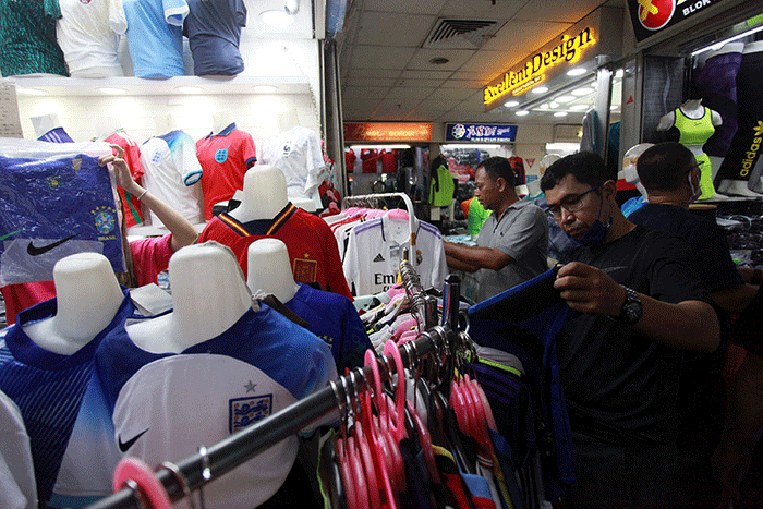 Pedagang menunjukan kostum tim sepak bola peserta Piala Dunia 2022 Qatar di salah satu kios di Blok B Pasar Tanah Abang, Jakarta, Sabtu (19/11/2022).