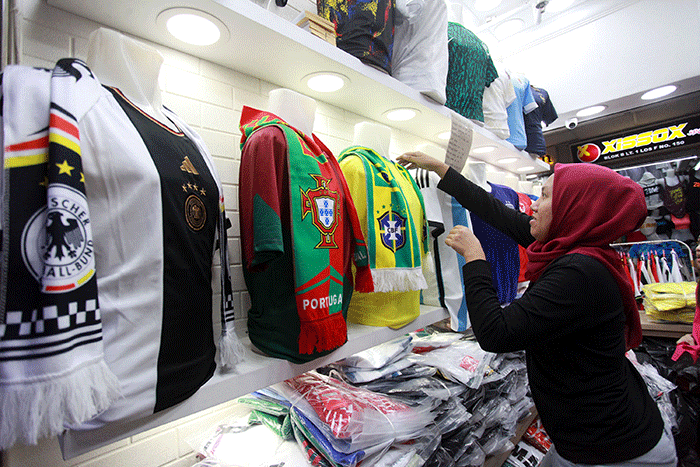 Pedagang menunjukan kostum tim sepak bola peserta Piala Dunia 2022 Qatar di salah satu kios di Blok B Pasar Tanah Abang, Jakarta, Sabtu (19/11/2022).