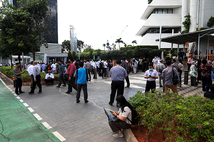 Sejumlah pekerja berhamburan keluar gedung setelah merasakan gempa di kawasan perkantoran di Jakarta, Senin (21/112022).