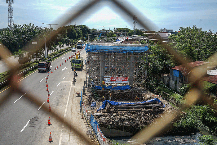 Pekerja beraktivitas di lokasi proyek jalan akses tol Makassar New Port (MNP) di Makassar, Senin (21/11/2022).