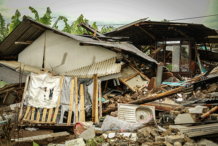 Seorang warga berfoto di depan rumah miliknya yang hancur akibat gempa di Kampung Barukaso, Desa Sukamulya, Kabupaten Cianjur, Jawa Barat, Rabu (23/11/2022).
