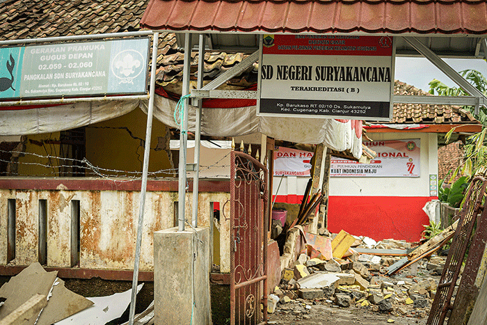 Seorang warga berfoto di depan rumah miliknya yang hancur akibat gempa di Kampung Barukaso, Desa Sukamulya, Kabupaten Cianjur, Jawa Barat, Rabu (23/11/2022).