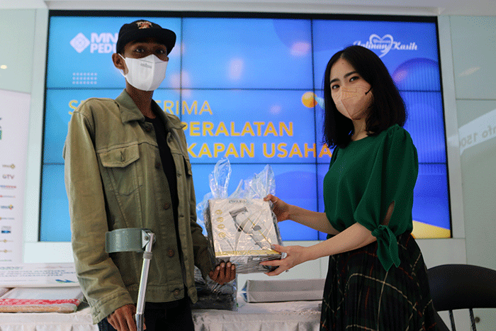 Ketua MNC Peduli Jessica Tanoesoedibjo (kanan) memberikan bantuan secara simbolis kepada Jahidi, Penderita Kelainan Tulang Panggul.