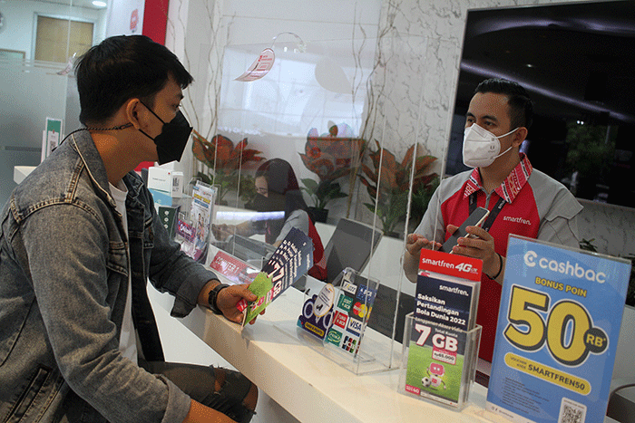 Customer service Gallery Smartfren menjelaskan aplikasi MySmartfren kepada pelanggan di Gerai Smartfren, Jakarta, Jumat (25/11/2022). 