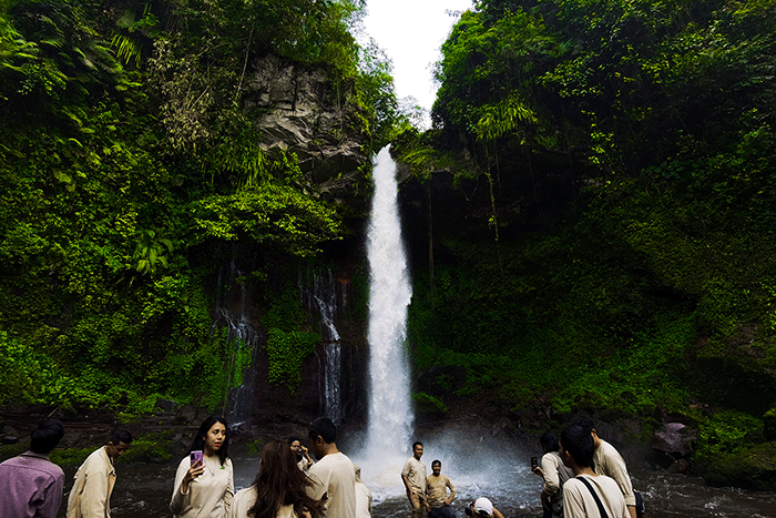 Pengunjung saat menikmati suasana keindahan air terjun curug Telu di lereng Gunung Slamet, Jawa Tengah, Minggu (27/11/2022).