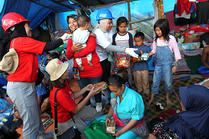 Volunteer Karyawan Prudential Indonesia berbincang dengan korban gempa usai membagikan bantuan di Desa Sukamulya, Cugenang, Kabupaten Cianjur.