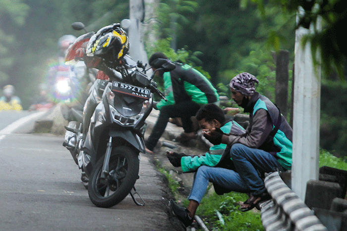 Pengendara ojek online (Ojol) saat melintas di kawasan Jakarta Timur, Rabu (30/11/2022). 