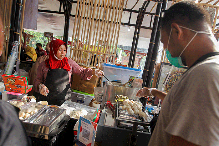 Penjual menunjukkan pempek jualannya dalam acara Expo Pempek 2022 di Mal Sarinah, Jakarta Pusat, Jumat (2/12/2022).