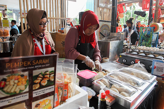 Penjual menunjukkan pempek jualannya dalam acara Expo Pempek 2022 di Mal Sarinah, Jakarta Pusat, Jumat (2/12/2022).