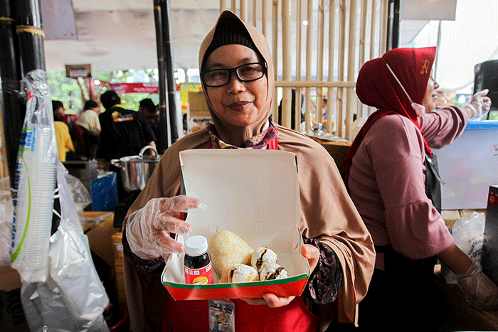 Penjual menunjukkan pempek jualannya dalam acara Expo Pempek 2022 di Mal Sarinah, Jakarta Pusat, Jumat (2/12/2022).