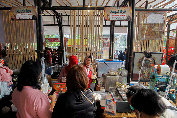 Penjual menunjukkan pempek jualannya dalam acara Expo Pempek 2022 di Mal Sarinah, Jakarta Pusat, Jumat (2/12/2022).