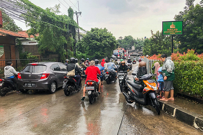 Pengendara motor nekat menerobos banjir di Jalan Radar Auri, Cimanggis, Depok, Jawa Barat, Senin (5/12/2022).