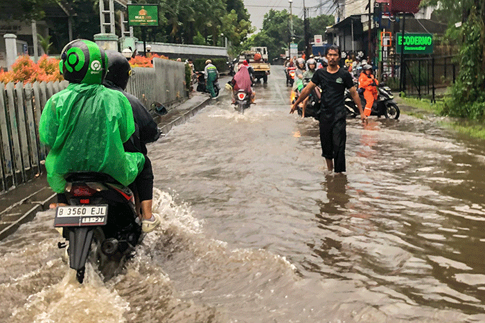 Pengendara motor nekat menerobos banjir di Jalan Radar Auri, Cimanggis, Depok, Jawa Barat, Senin (5/12/2022).