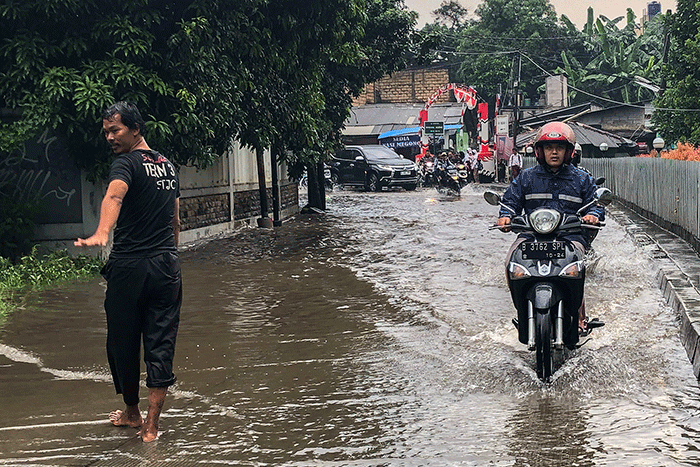 Pengendara motor nekat menerobos banjir di Jalan Radar Auri, Cimanggis, Depok, Jawa Barat, Senin (5/12/2022).