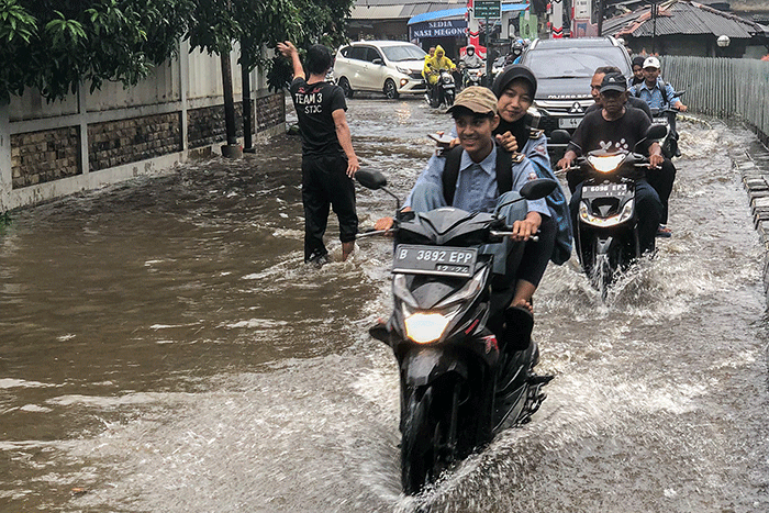 Pengendara motor nekat menerobos banjir di Jalan Radar Auri, Cimanggis, Depok, Jawa Barat, Senin (5/12/2022).
