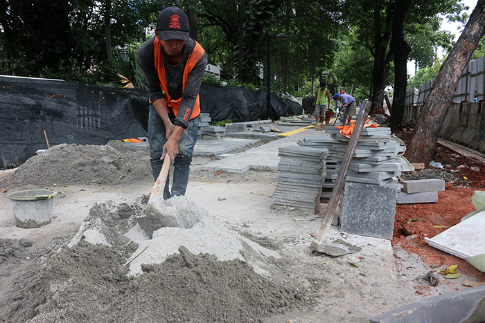 Pekerja saat menyelesaikan proyek revitalisasi trotoar di kawasan Jalan Medan Merdeka, Jakarta, Selasa (6/12/2022).