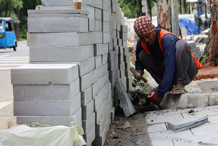 Pekerja saat menyelesaikan proyek revitalisasi trotoar di kawasan Jalan Medan Merdeka, Jakarta, Selasa (6/12/2022).