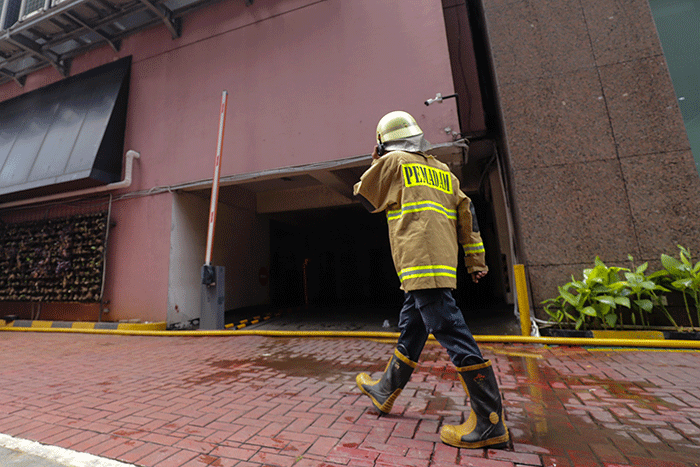 Sejumlah petugas Pemadam Kebakaran (Damkar) melintas usai terjadi kebakaran di depan gedung Imigrasi Kantor Kementerian Hukum dan Hak Asasi Manusia.