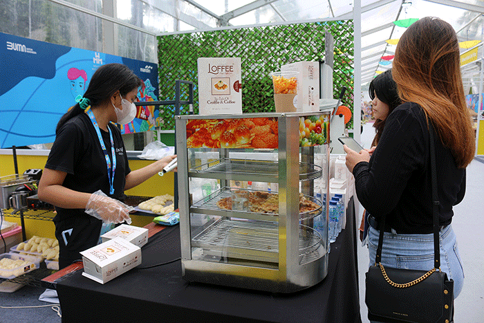 Pengunjung memesan menu makanan di Loffee Croffle & Coffe di pameran Wirausaha Muda Mandiri (WMM) Fest 2022 di Plaza Barat Senayan, Jakarta, Sabtu (10/12/2022).
