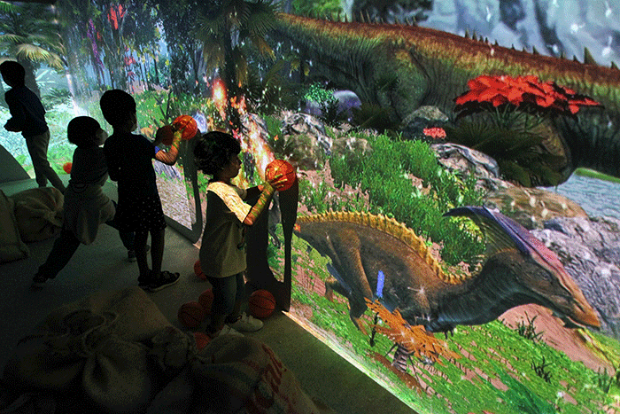 Pengunjung merasakan sensasi dalam wahana Dino Xscape di Lippo Mall Kemang, Jakarta, Jumat (9/12/2022).