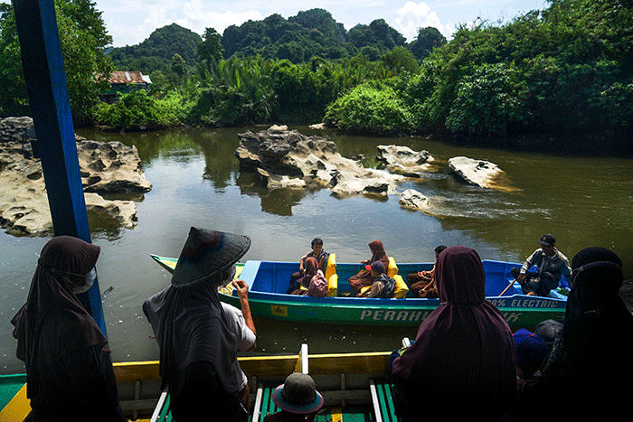 Sejumlah anak sekolah dan warga menumpangi perahu listrik di kawasan Desa Salenrang, Kabupaten Maros, Sabtu (10/12/2022).
