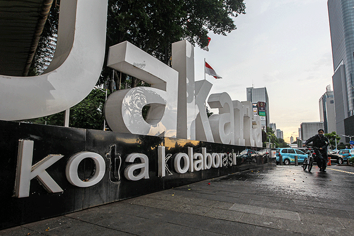 Warga dengan mengunakan payung menerjang hujan saat jam pulang kerja di kawasan Jalan Jenderal Sudirman, Jakarta, Senin (12/12/2022).