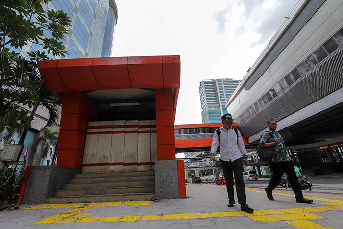 Warga melintas didekat proyek Stasiun Lintas Raya Terpadu (LRT) Rasuna Said, Kuningan, Jakarta Selatan, Rabu (14/12/2022).