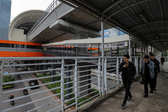 Warga melintas didekat proyek Stasiun Lintas Raya Terpadu (LRT) Rasuna Said, Kuningan, Jakarta Selatan, Rabu (14/12/2022).