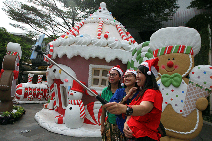 Pengunjung berfoto dengan latar dekorasi perayaan Natal dan Tahun Baru 2023 di Summarecon Mall Kelapa Gading, Selasa (13/12/2022).