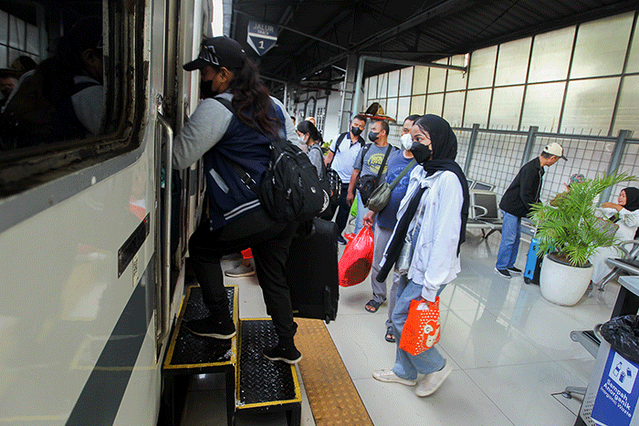 Sejumlah penumpang menaiki kereta di Stasiun Pasar Senen, Jakarta, Jumat, (16/12/2022).