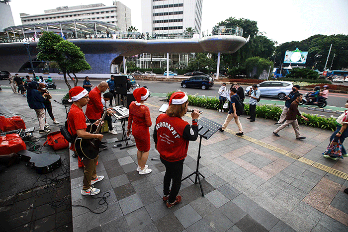 Musisi menyanyikan lagu bertemakan Natal di kawasan Bunderan HI, Jakarta, Senin (19/12/2022).