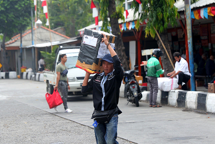 Penumpang berjalan menuju bus antarkota antarprovinsi (AKAP) di Terminal Kalideres, Jakarta Barat, Rabu (21/12/2022).