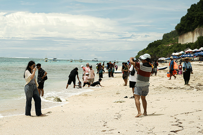 Wisatawan berswafoto di Pantai Pandawa, Kuta Selatan, Bali, Rabu (21/12/2022).