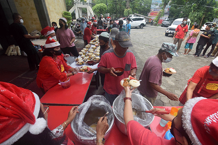 Ibu-ibu relawan Piring Kasih berbagi makan siang gratis kepada masyarakat di pelataran Gereja St Theresia Bongsari Semarang, Jawa Tengah, Kamis (22/12/2022).