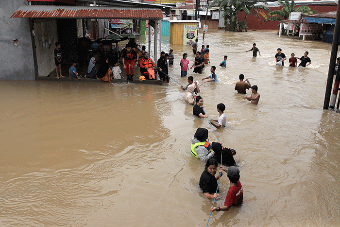 Sejumlah warga melewati banjir di Jalan Poros Nipa Nipa Antang, Makassar, Minggu (25/12/2022).