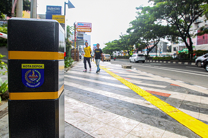 Pejalan kaki melintas di trotoar yang direvitalisasi di Jalan Margonda Raya, Depok, Jawa barat, Senin (26/12/2022).